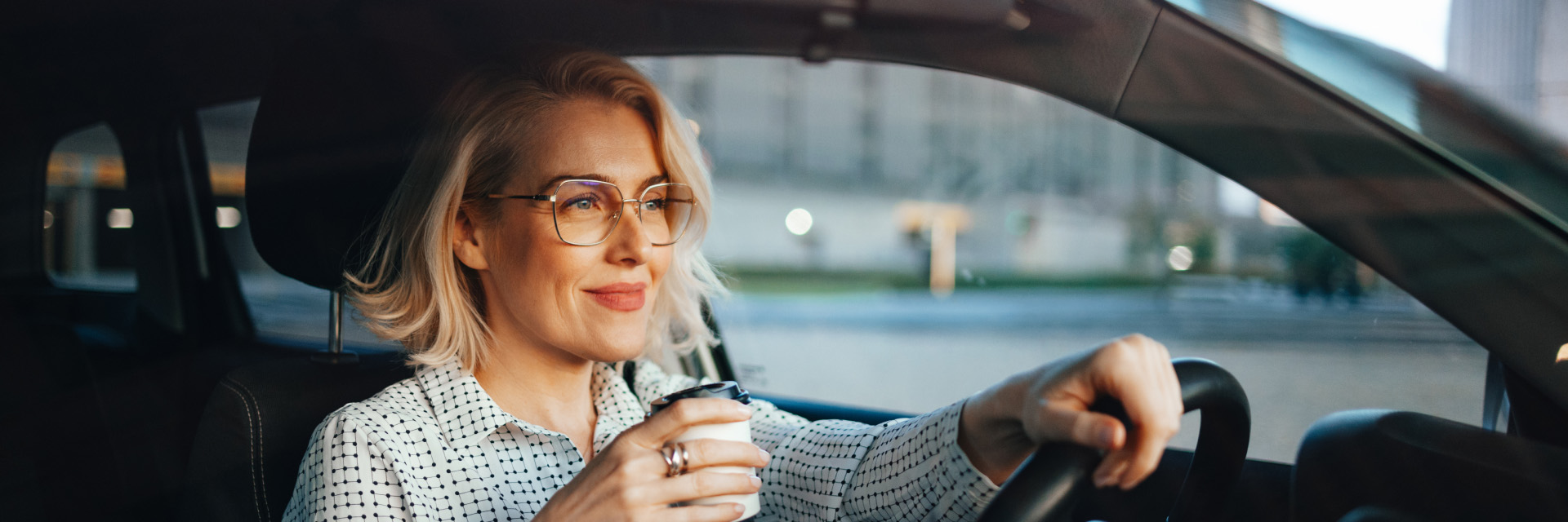 Woman driving with coffee cup