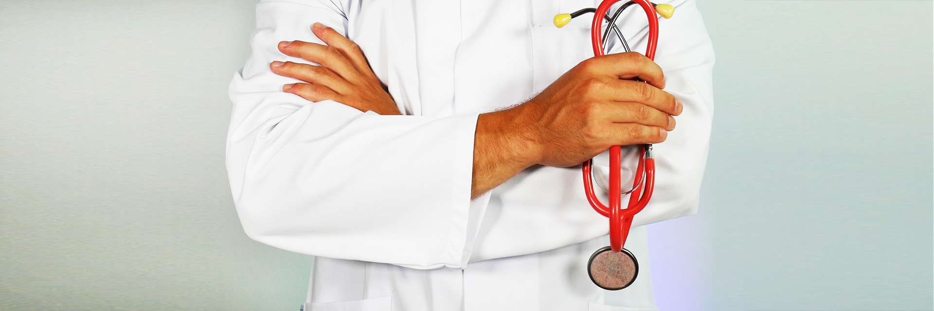 Doctor with Arms Folded Holds a Red Stethoscope