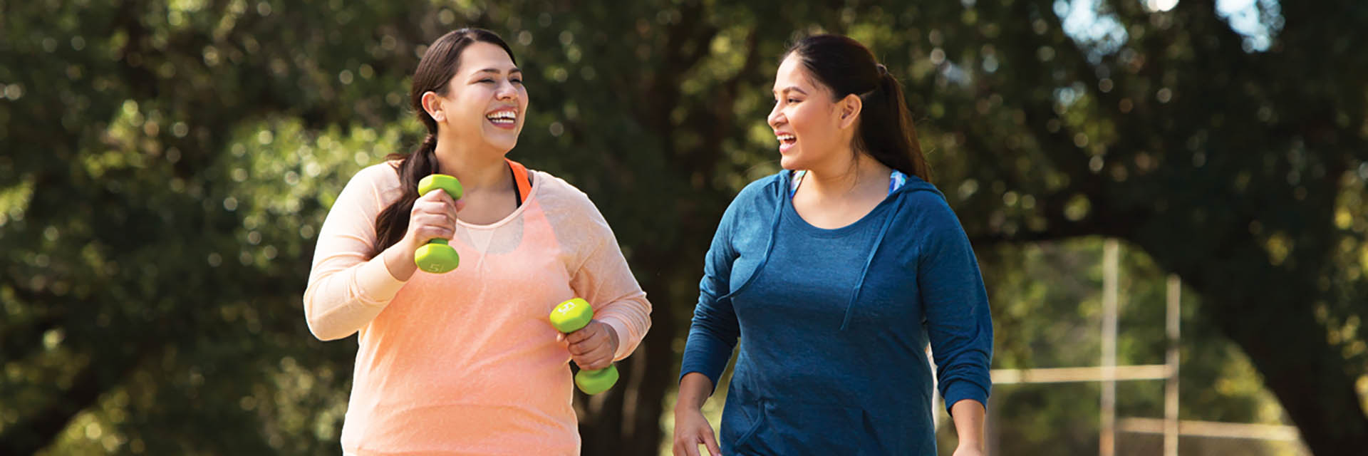 Women walking outdoors with weights