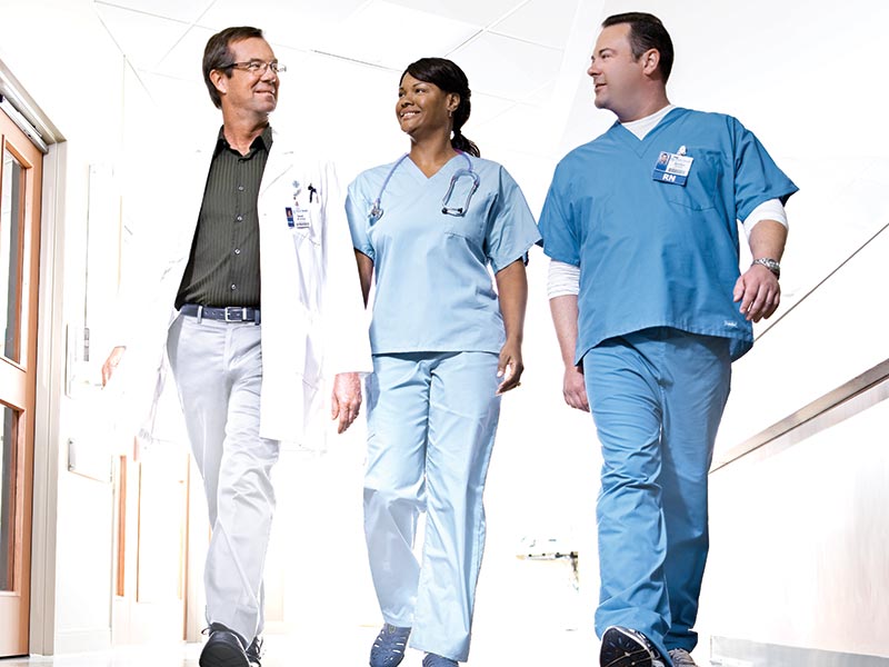 Physician and Nurses Walking in Hallway