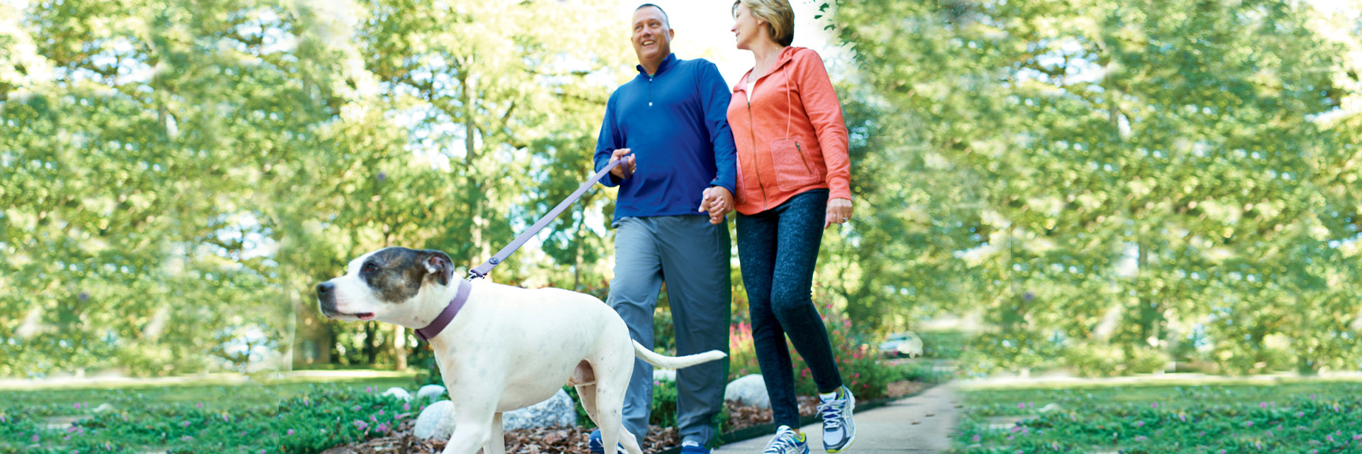 Couple walking dog outside