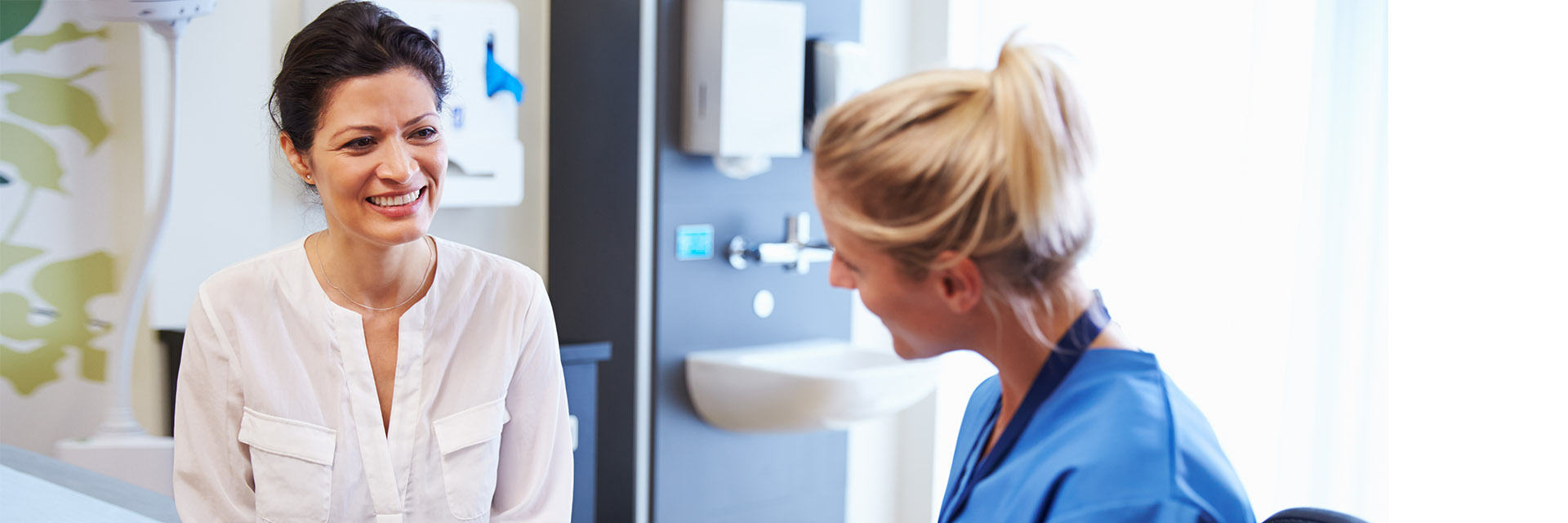 Female Nurse in Exam Room with Female Patient
